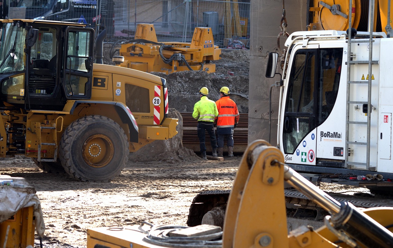 A construction site with a large cement block and a yellow and black truck