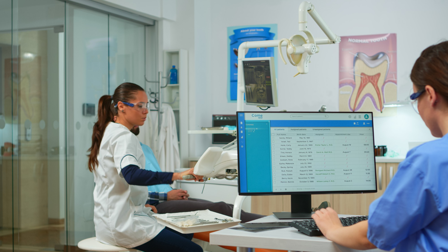 A woman is sitting at a desk with a computer